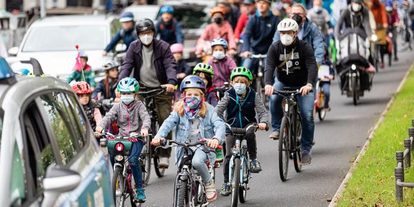 Kinder fahren auf einer Fahrraddemo eine Straße entlang